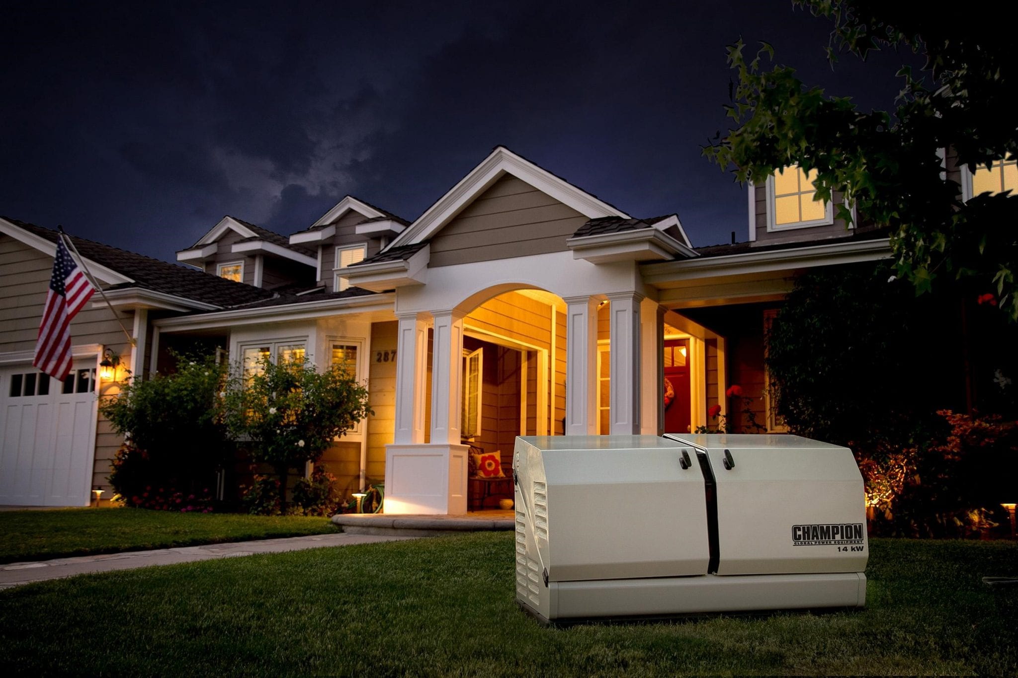 Champion residential generator in the foreground of a private, suburban home at night.