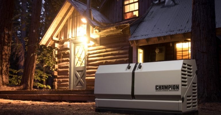 Champion home standby generator installed in front of a rural cabin at night.