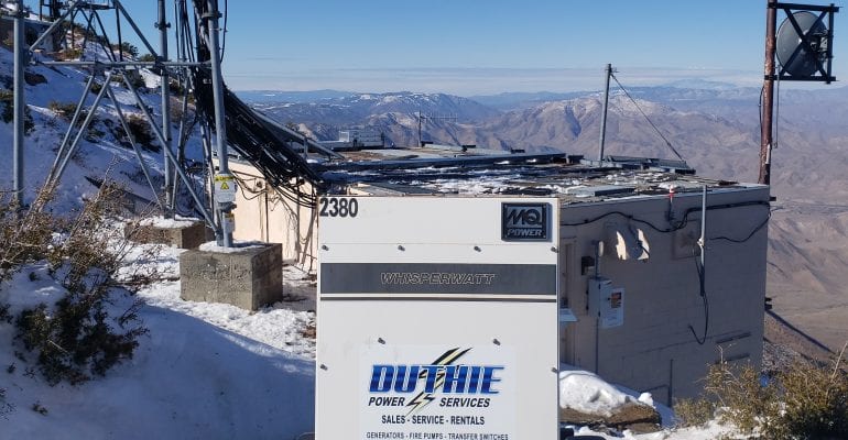 Duthie Power Services rental generator on a snowy mountaintop overlooking a valley.