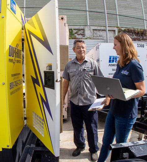 Corinne Rodriguez and Steve Matsumoto inspecting a generator